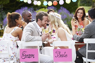 Bride And Groom Enjoying Meal At Wedding Reception